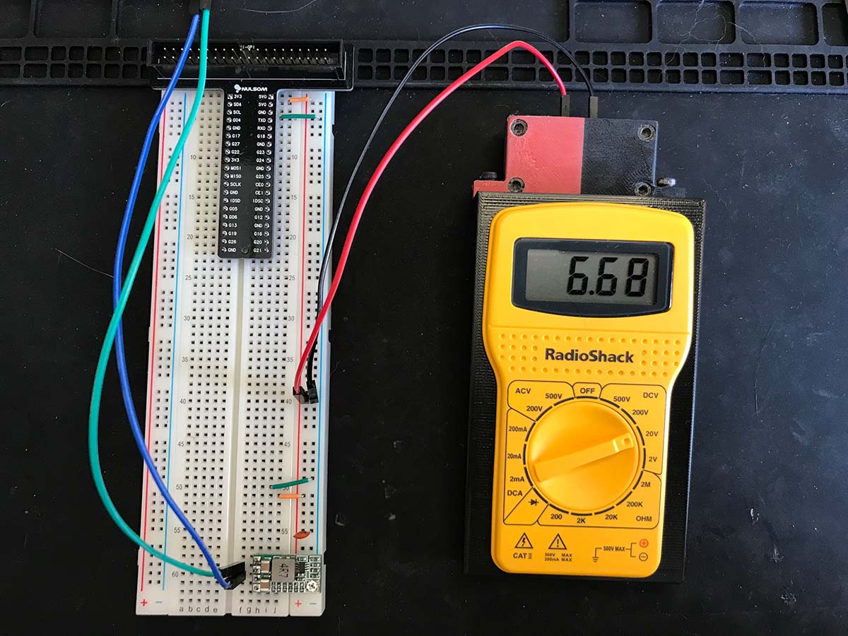 Meter being used with a breadboard showing a measured DC voltage of 6.68