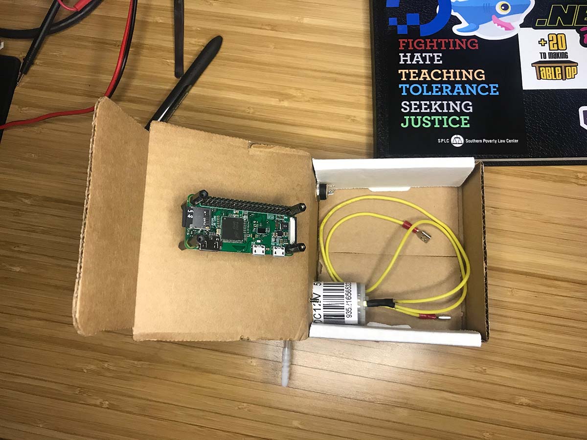Cardboard box with a Raspberry Pi Zero W and a small pump motor mounted inside