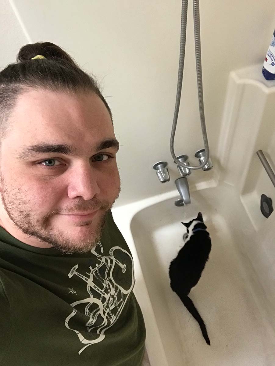 Selfie with my cat drinking from the tub faucet in the background